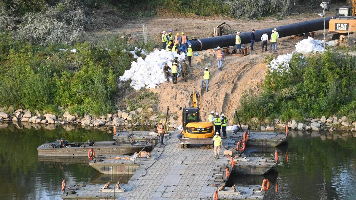 Zastępczy rurociąg wciągnięty wieczorem na początek mostu pontonowego