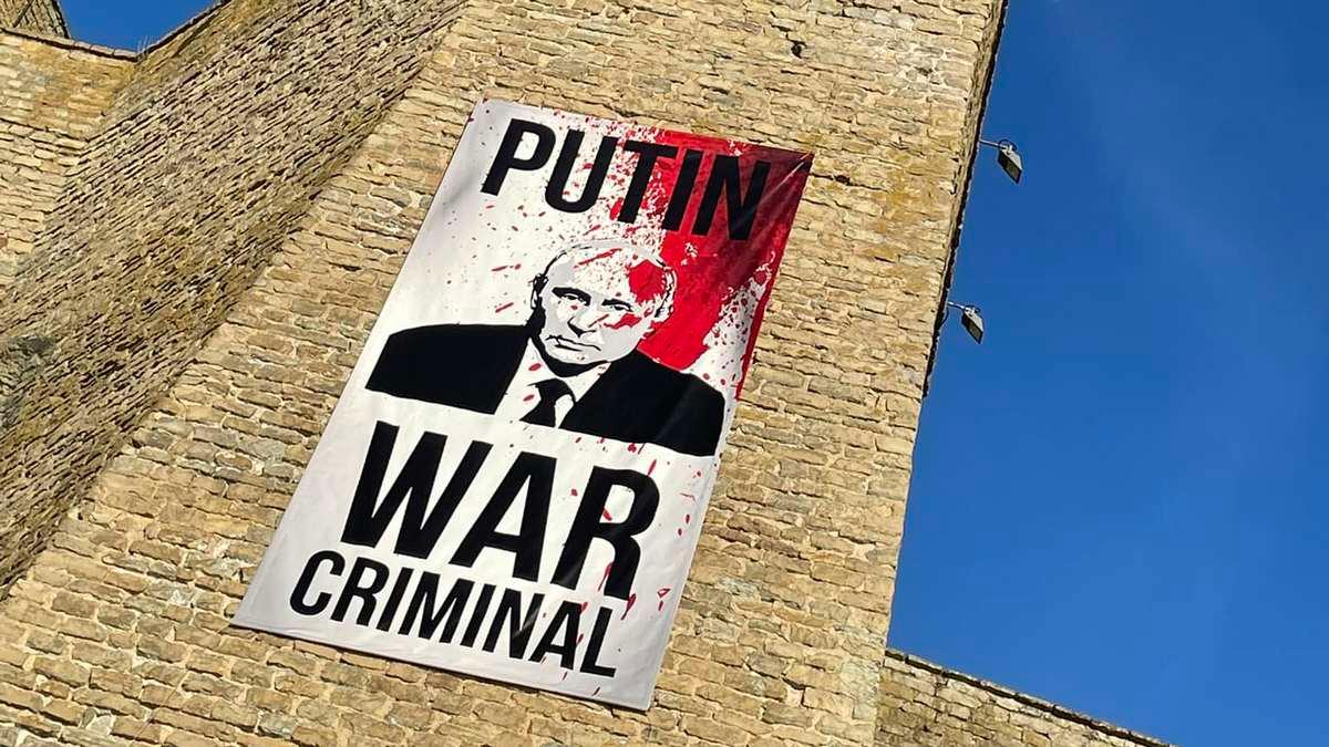 "Putin - zbrodniarz wojenny". Wielki plakat przy granicy zwrócony w stronę Rosji