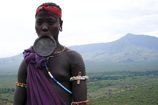 Kobieta z pasterskiego plemienia Mursi zamieszkującego Etiopię. Krążek umieszcza się w rozciętej dolnej wardze kobiety, kiedy osiąga dorosłość. Im jest większy, tym bardziej kobieta jest atrakcyjna w oczach mężczyzn z plemienia. 